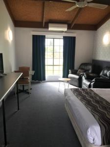 a hotel room with a bed and a couch at Bakery Park Motor Inn in Tocumwal