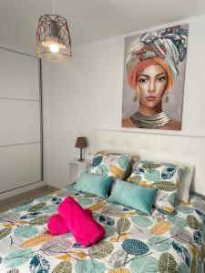 1 dormitorio con 1 cama con una pintura en la pared en CASA MARINA en Costa Teguise