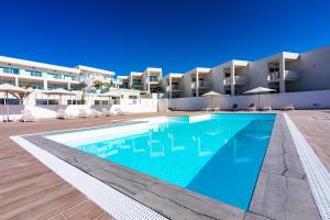 une grande piscine devant un immeuble dans l'établissement CASA MARINA, à Costa Teguise