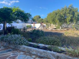 a garden with flowers and a playground in the background at Casa Palmeral in Mácher