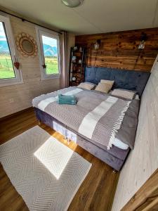a bedroom with a large bed and two windows at Liptovalley- mobilné domy s wellnessom in Liptovská Kokava