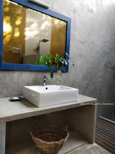 a bathroom with a white sink and a mirror at Gaia Lake Bungalow, Kandalama in Dambulla
