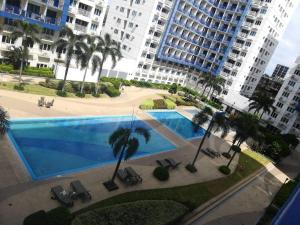 an overhead view of a swimming pool with palm trees and buildings at Aj booking in Manila