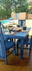 a blue picnic table with two chairs and a plate of food at Gaia Lake Bungalow, Kandalama in Dambulla