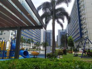 a playground in a city with palm trees and buildings at Aj booking in Manila