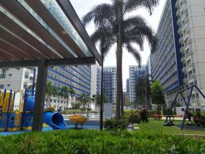 een speeltuin in een stad met palmbomen en gebouwen bij Aj booking in Manilla