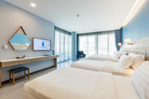 a hotel room with two beds and a television at BlueSotel Krabi AoNang Beach- SHA Extra Plus in Ao Nang Beach