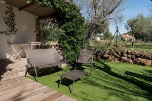 eine Terrasse mit zwei Stühlen und einem Tisch im Gras in der Unterkunft Maison 2/4pers : jardin piscine. LES AMANDIERS in Lorgues