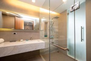 a bathroom with a shower, sink, and mirror at BlueSotel Krabi AoNang Beach- SHA Extra Plus in Ao Nang Beach