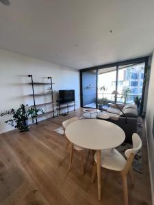 een woonkamer met een tafel en een bank bij KozyGuru Bondi Junction Lovely 1 Bedroom Walk to Station NBD241 in Sydney