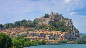 a city on top of a hill next to a body of water at Agréable appartement au calme in Villeneuve