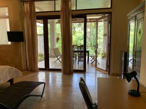 een woonkamer met een bed, een tafel en stoelen bij Wonder-Land Villa in Ubud