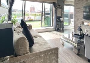 a living room with a couch and large windows at Glasgow two bedroom Penthouse in Glasgow