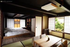 Fukusaki的住宿－NIPPONIA HARIMA FUKUSAKI ZOUSHONO YAKATA，卧室配有一张床和一张桌子及椅子