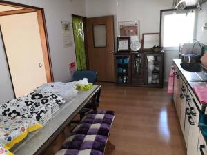 a room with a kitchen with a table and a counter at shiokaze guest house / Vacation STAY 6794 in Matsuyama