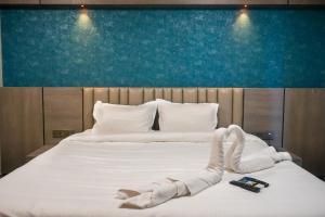 Hotel VR Grand في Vizianagaram: غرفة نوم بها سرير مع جهازين تحكم عن بعد