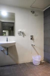 Hotel VR Grand في Vizianagaram: حمام مع حوض ومرآة على الحائط