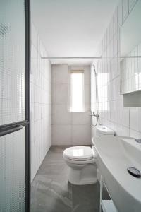 a white bathroom with a toilet and a sink at M Village Living 47 Thảo Điền in Ho Chi Minh City +15 photos