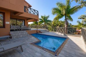 a patio with a swimming pool and a house at San Lameer Villa - 14014 - 5 Bedroom Luxury - 10 pax - San Lameer Rental Agency in Southbroom