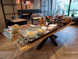 - une longue table avec de la nourriture dans un restaurant dans l'établissement Hotel De Dennen, à Egmond aan Zee
