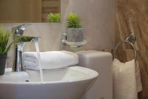 a bathroom with a sink and a toilet with towels at Tia Maria is situated in the southern part of the Sunny Beach Resort in Sunny Beach