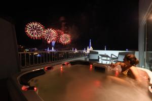 a woman sitting in a bath tub with fireworks at Victoria by Petit Chic in Mellieħa