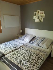 - un lit dans une chambre avec des photos sur le mur dans l'établissement Feriendomizil am Zeulenrodaer Meer, à Zadelsdorf