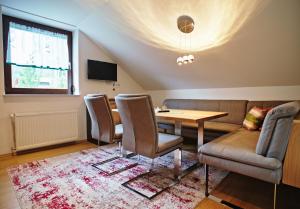 ein Wohnzimmer mit einem Sofa, einem Tisch und Stühlen in der Unterkunft Alpengasthaus Gießlhütte in Wolfsberg
