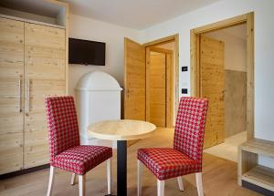 a room with a table and two chairs at Hotel Shandranj in Tesero