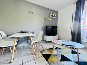 a living room with a table and chairs and a tv at Le Prorel appartement au pied du télécabine in Briançon