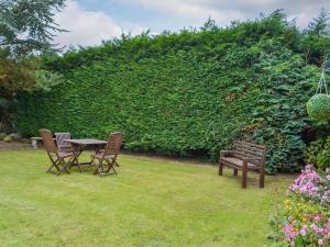 two chairs and a table and a bench in a yard at The Forge in Tumby