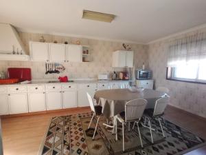 a kitchen with a table and chairs in a room at Apartamento T3 Furadouro in Ovar