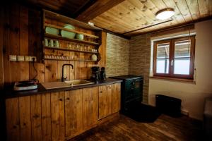 una cucina con armadi in legno, lavandino e finestra di Almhütte Hebalm a Pack