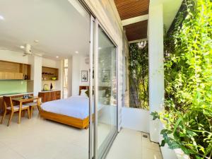 a bedroom and kitchen with a bed and a table at Babylon Garden Da Nang in Danang
