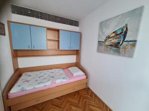una piccola camera con un letto e un quadro di Dolores Apartment a Opatija