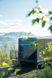 einen Fernseher auf einem Gebäude mit Bergen im Hintergrund in der Unterkunft NARVIKFJELLET Camp 291 in Narvik