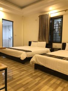 a hotel room with two beds and a window at Minh Anh House in Sa Pa