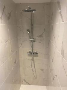 een douche met een douchekop in de badkamer bij Les Dunes in Saint-Valery-sur-Somme