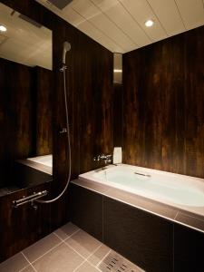 a bath tub in a bathroom with wooden walls at HOTEL Us Racecourse Adult only in Niigata