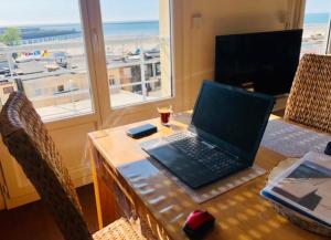ブローニュ・シュル・メールにある"BELLEVUE" Magnifique appartement vue sur mer et face à Nausicàaの- 海の景色を望むテーブルに座ったノートパソコン