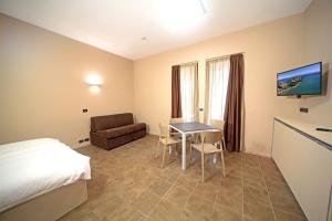 ein Hotelzimmer mit einem Bett, einem Tisch und einem Stuhl in der Unterkunft Smeraldo apartments in Sirmione