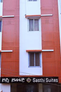 a tall red brick building with windows on it at Sasthi Suites in Bangalore