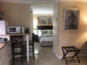 a room with a bed and a kitchen with a microwave at Somerset Lodge in Montagu