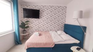 a bedroom with a bed and a tv on a wall at Na Szaniec 17 by Homeprime in Krakow