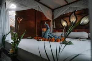 a bed with a statue of a dinosaur on top of it at Aroma De La Mer in Amed