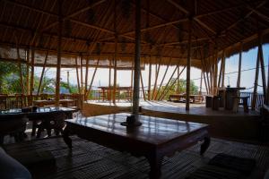 a room with tables and a large straw roof at Aroma De La Mer in Amed