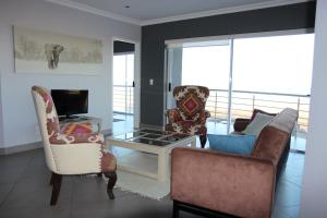 a living room with two chairs and a fireplace at Atlantic Dunes Unit 11, Self Catering in Rand Rifles