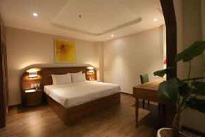 Habitación de hotel con cama y maceta en Lanura Apartments and Hotel, en Ho Chi Minh