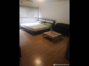 1 dormitorio con cama y mesa de centro en Thailand Taxi Apartment Hostel, en Thung Si Kan