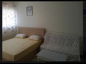 two beds in a small room with a window at Thailand Taxi Apartment Hostel in Thung Si Kan
